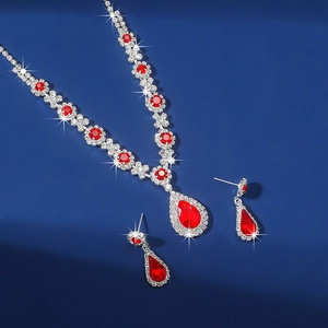 Macro shot of silver-tone jewelry set with red teardrop crystals and sparkling rhinestones