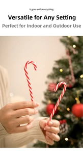 Close-up of red and white striped candy cane Christmas ornaments held in hands