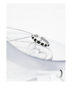 Macro detail of silver S925 ring with black square inlay on minimalist glass background
