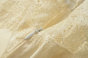 Détail de fermeture éclair invisible sur robe en satin beige avec dentelle florale