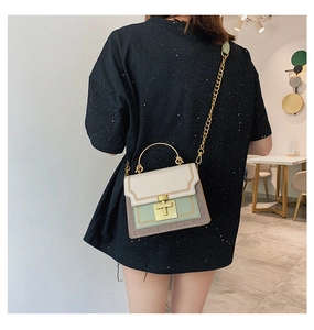 Detail of a chic tricolor woven crossbody bag with gold chain strap on a model
