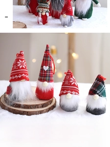 Close-up of four handmade Christmas gnomes on fur rug with festive bokeh light background
