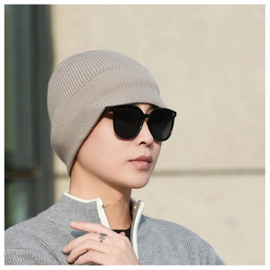 Close-up of beige ribbed knit beanie texture and fit on male model for winter warmth