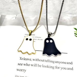 Close-up of black and white ghost pendants on gold and silver stainless steel chains