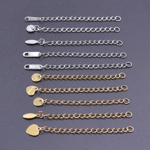 Detailed view of gold and silver stainless steel necklace extension chains with metal tags