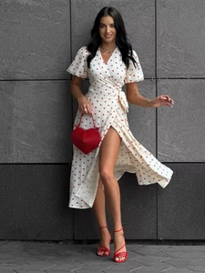 Detail of red heart print on white wrap dress with puff sleeves and tie waist