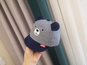 Detailed close-up of blue and white striped baby baseball cap with 3D bear ears