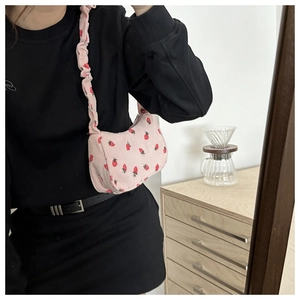 Detailed close-up of a pink corduroy underarm bag with sweet strawberry prints