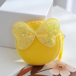 Cute round yellow plush coin purse with a sequined bow on a minimalist gift box
