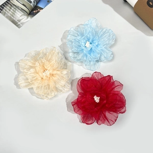 Détail de barrettes à fleurs en organza faites main en bleu, beige et rouge bordeaux
