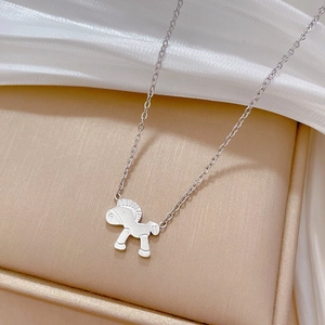 Detailed view of a silver pony pendant necklace resting on a premium gift box