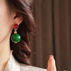 Gros plan de boucles d'oreilles vintage style palais avec perles rouges et vertes