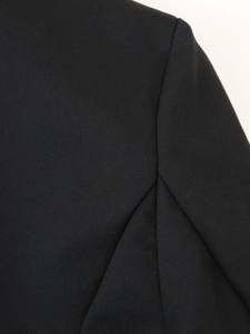 Dettaglio della cucitura e trama saia sul tessuto nero dell'abito blazer elegante