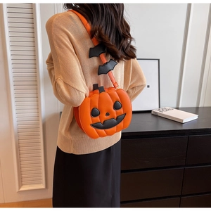 Halloween pumpkin shoulder bag with bat strap detail shown on a model's back view