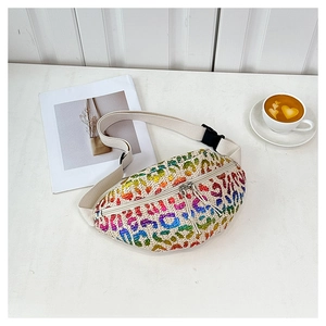 Straw waist bag with rainbow leopard print pattern and dual zippers on wooden table