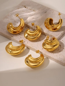 Macro view of polished chunky C-shape hoop earrings with 18K gold PVD plating texture