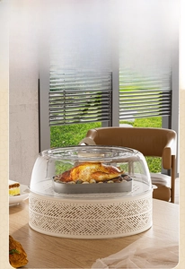 Close-up of glass food cover with hollow base on wooden table in a sunny dining setting