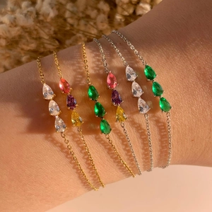 Elegant stainless steel bracelets with pear-cut colorful zircons on a model's wrist