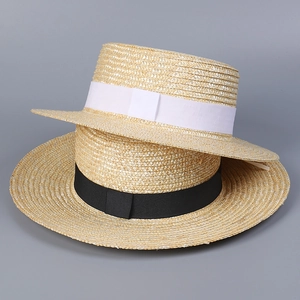 Detail of flat top straw boater hats with elegant black and white ribbon bow decorations