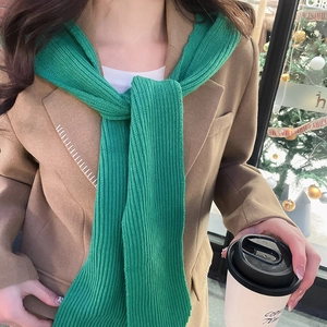 Detail of green knitted hood scarf with thick texture on brown blazer outfit