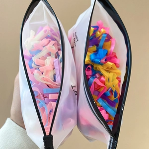 Detail of colorful high-elastic hair bands in macaron colors and frosted zipper bag