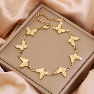 Elegant gold butterfly stainless steel bracelet displayed on a luxury satin jewelry box