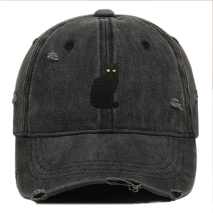 Close-up of distressed cotton baseball cap featuring detailed black cat embroidery