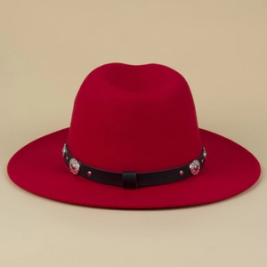 Detail of red fedora hat featuring black leather band with silver metal rivets and studs