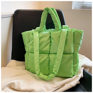 Detailed view of the bright green quilted tote bag with soft down padding and shoulder strap