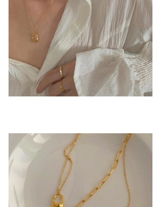 Close-up of luxury pearl chain necklace with geometric pendant and matching gold rings