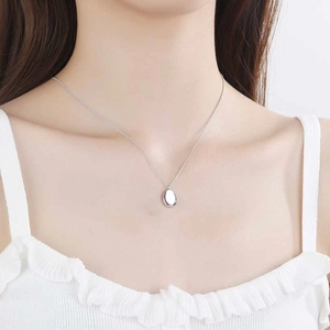 Minimalist S925 sterling silver necklace with oval pendant worn by a model on neck