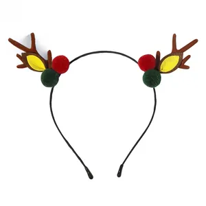 Close-up of Christmas reindeer antlers headband with festive red and green plush poms