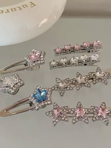 Close-up of sparkling silver star hair clips with pink and blue rhinestones on mirror