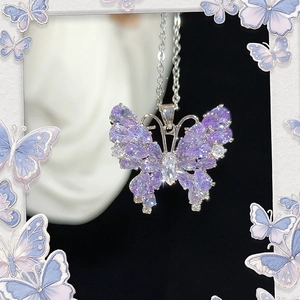 Detail view of purple butterfly pendant necklace with sparkling cubic zirconia on a white mannequin