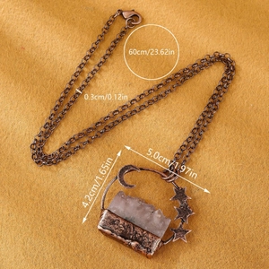 Vintage copper necklace with amethyst crescent moon and star pendant on brown felt
