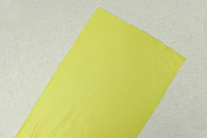 Detailed view of vibrant neon yellow woven fabric with a smooth lustrous texture