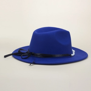 Detail of royal blue fedora hat featuring a black satin bow and elegant pearl accent