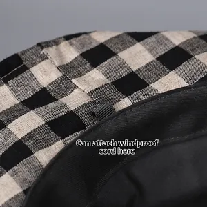 Detail of the checkered linen sun hat featuring a small loop for attaching a windproof rope