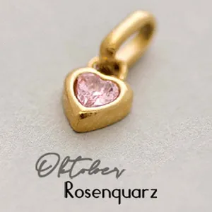 Detailed macro shot of gold heart pendant featuring October rose quartz gemstone