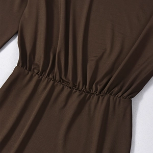 Detail of dark brown dress featuring gathered waist pleats and smooth fabric texture