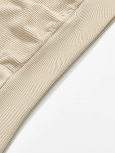 Close-up of beige knit sweatshirt showing high-quality ribbed hem and soft fabric texture