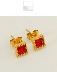Detail of square gold plated stud earrings with red zircon stones and bead settings