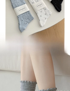 Détail des revers à volants et motifs à pois sur des chaussettes en coton côtelé