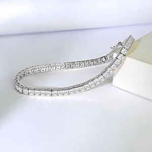 Macro shot of silver tennis bracelet with square-cut cubic zirconia on white display