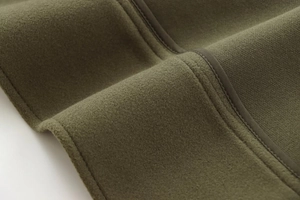 Détail du tissu en feutre vert olive montrant les coutures et la texture polaire douce