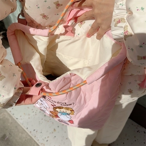 Detail view of pink quilted tote interior with girl and bear embroidery