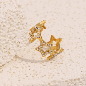 Close-up of 18K gold plated star ring with white zircons on a white natural stone