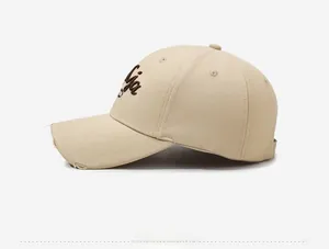 Detail view of beige distressed cotton baseball cap with Lydia 3D embroidery on the side