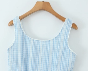 Close-up of blue plaid cotton fabric with delicate white lace trim on the neckline