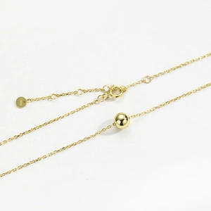 Detailed macro view of S925 sterling silver golden bead necklace with lobster clasp